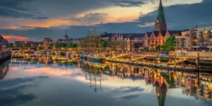 Cityline view of Bremen, Germany, with a church steeple next to a river